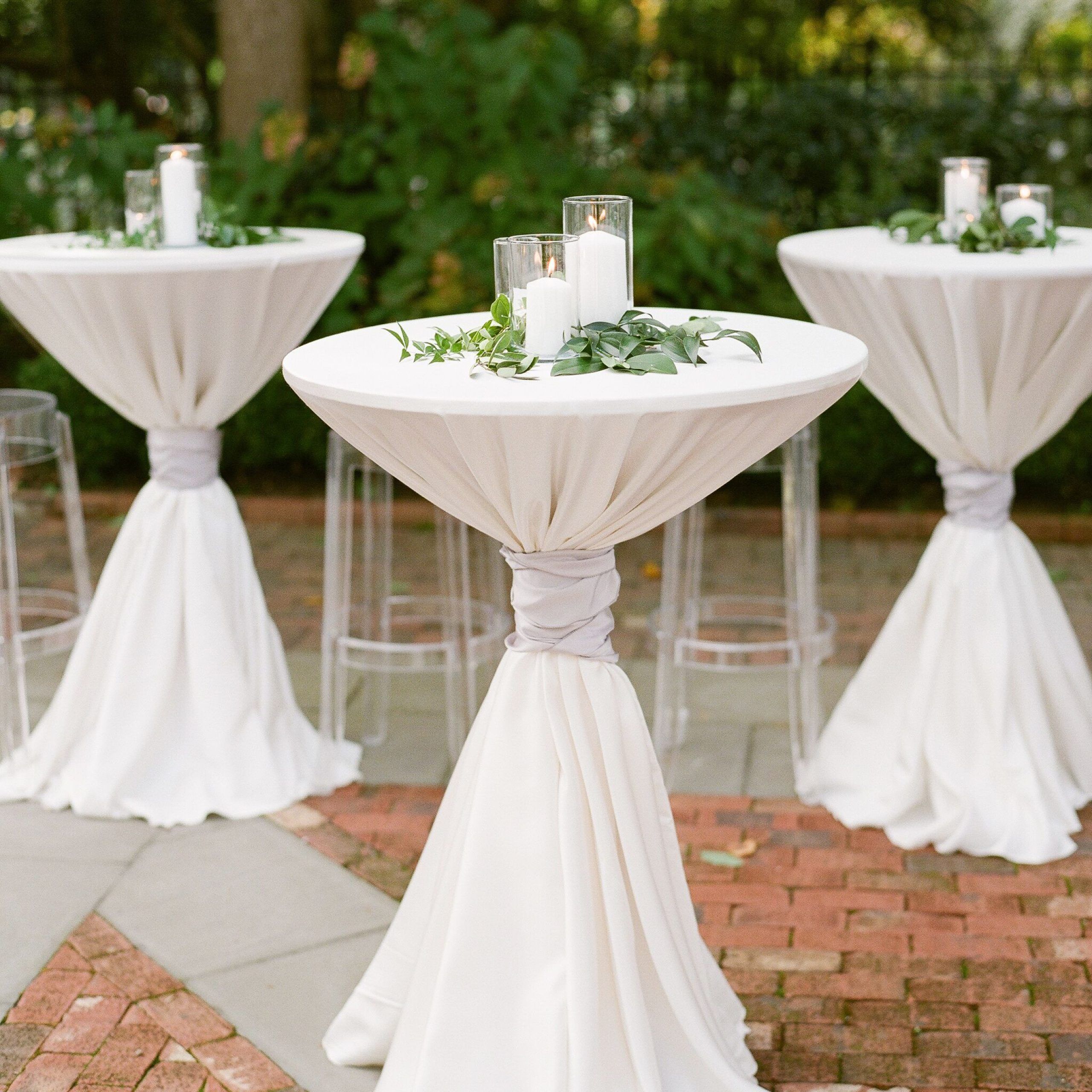 White Pillar Candles And Greenery Atop Cocktail Tables | Wedding With Regard To Natural Outdoor Cocktail Tables (View 12 of 15)